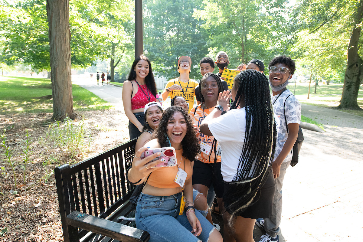 Students pose for a selfie on a bench at The College of Wooster